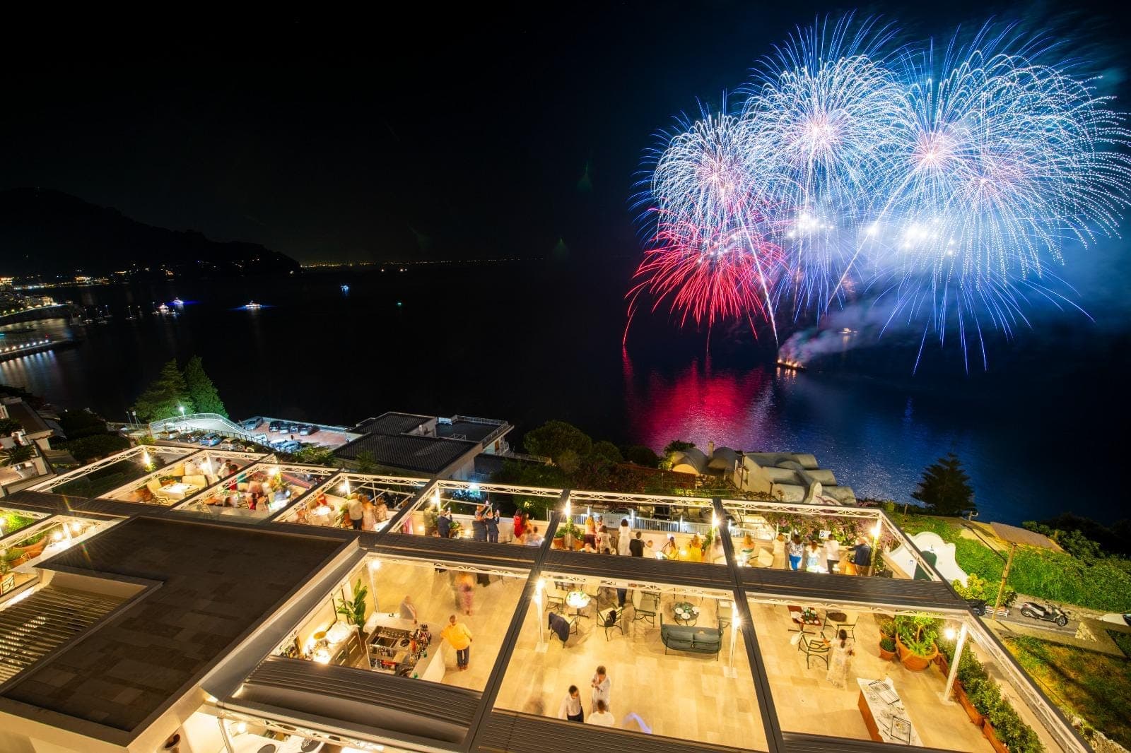 La terrazza coperta di sera, illuminata, durante i fuochi d'artificio sul mare